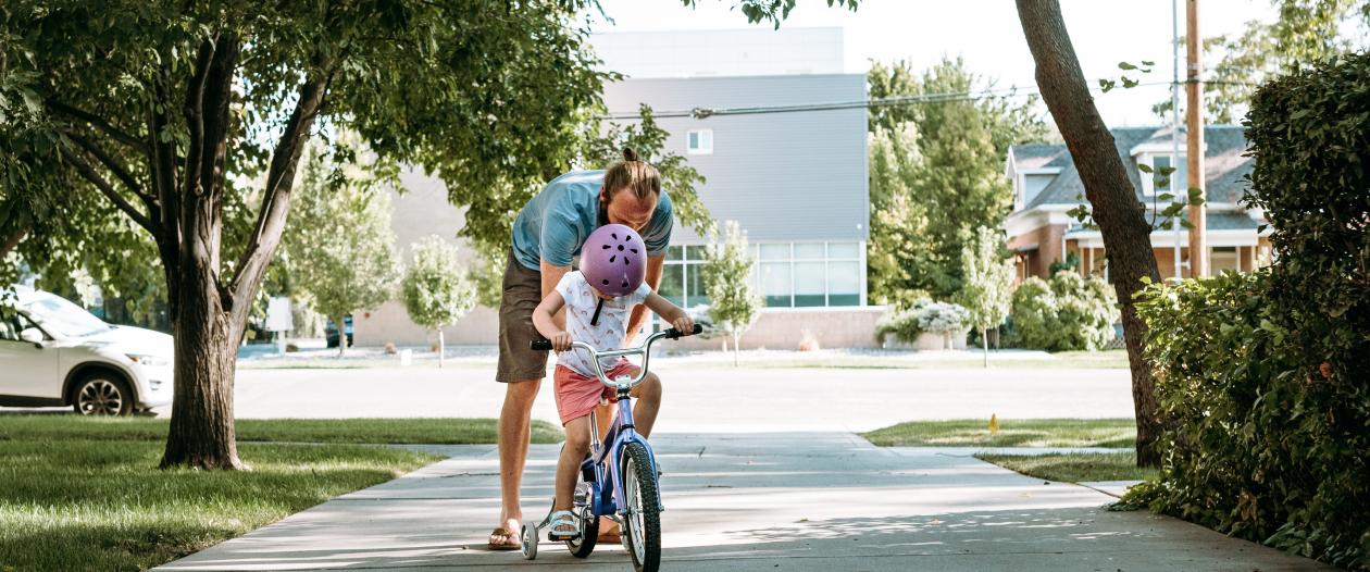 Un père qui apprend à sa fille à rouler sur un vélo de location Loopz