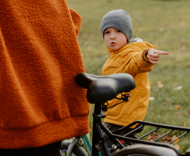 Jeune garçon qui fait du vélo avec ses parents sur un vélo loué chez Loopz